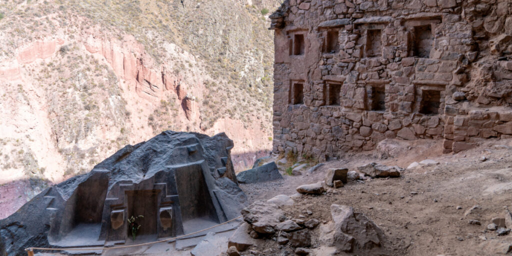 Ancient stone structure and carved rock altar at Ñaupa Iglesia near Ollantaytambo, nestled in the rugged mountains of the Sacred Valley, Peru.