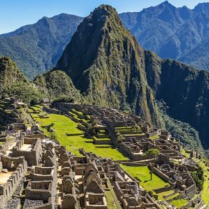 The Inca citadel of Machu Picchu, with stone ruins and green terraces below the iconic peak of Huayna Picchu mountain.