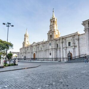 Front view of Arequipa’s Cathedral on the Plaza de Armas, with its twin towers and neoclassical facade under a clear sky.